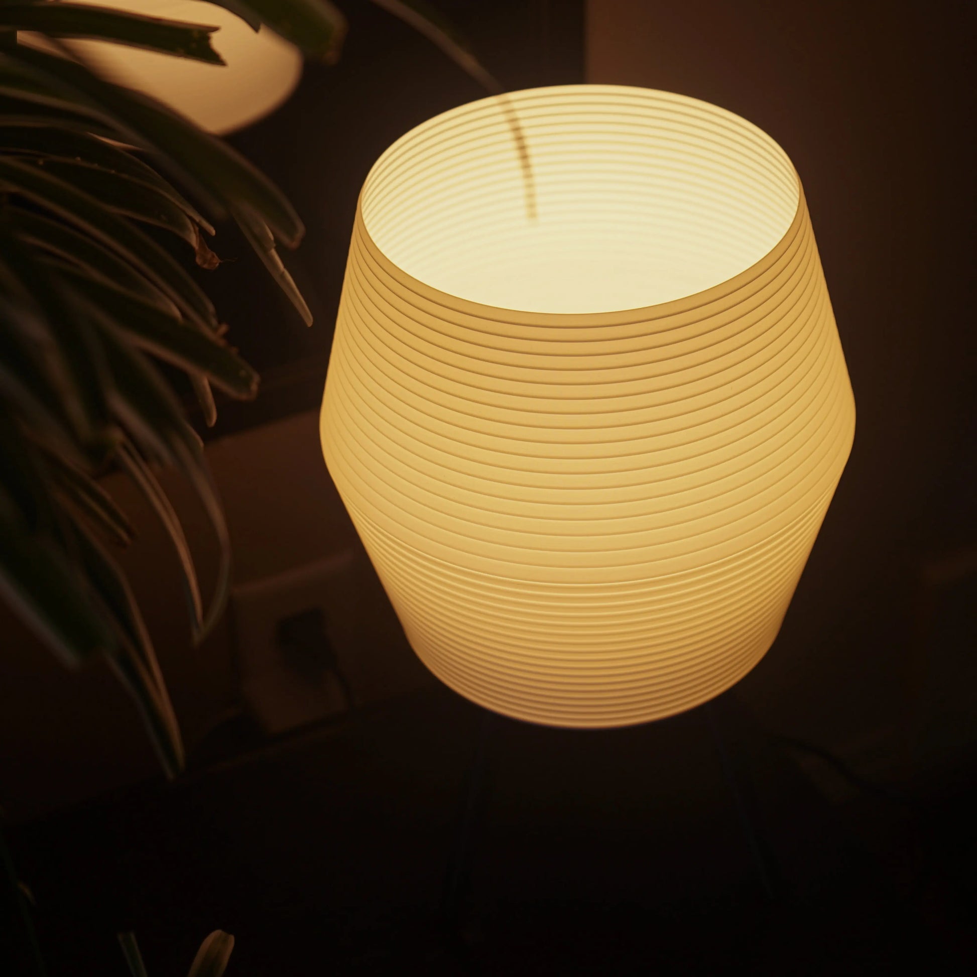 Textured table lamp emitting a warm glow in a dark setting