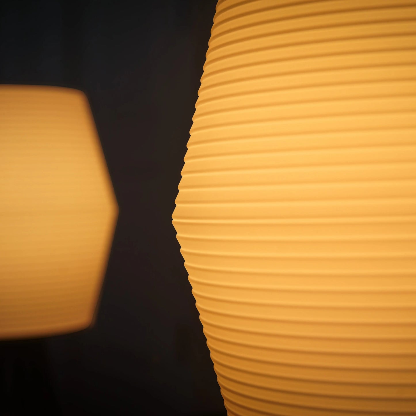 Two yellow textured lampshades against a dark background