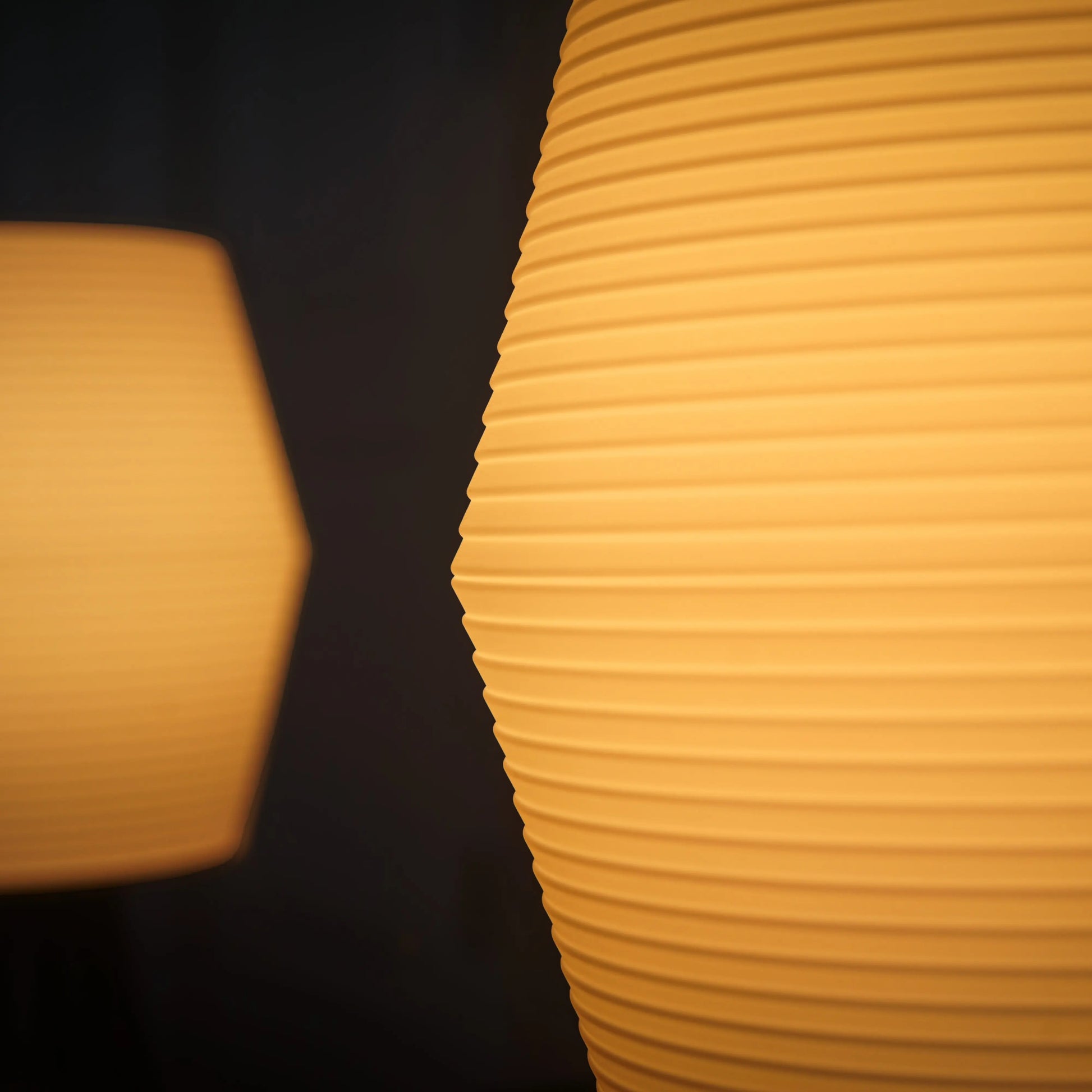 Two yellow textured lampshades against a dark background