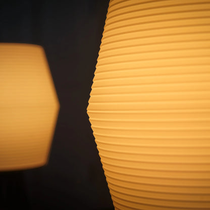 Two yellow textured lampshades against a dark background