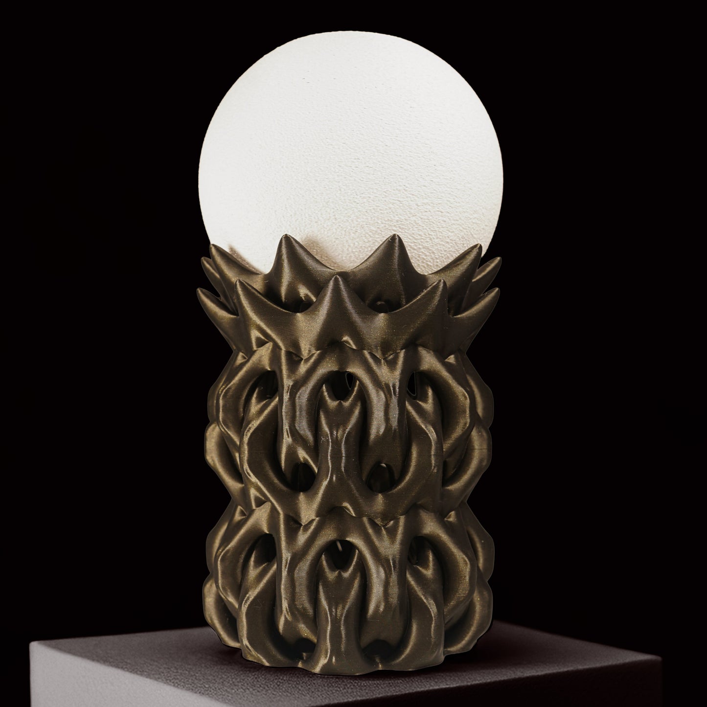 Decorative lamp with a white globe and ornate bronze base on a black background