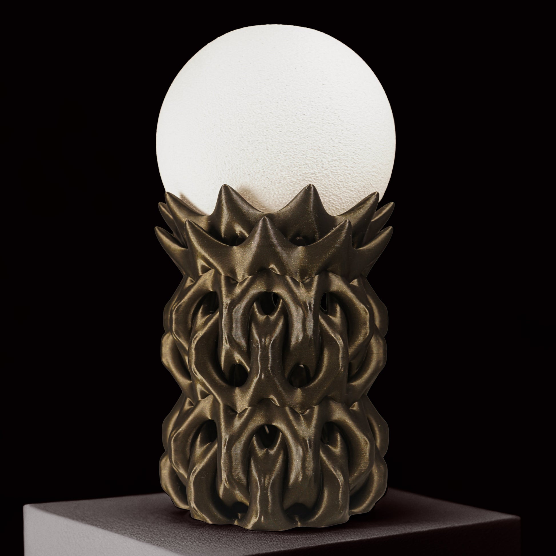 Decorative lamp with a white globe and ornate bronze base on a black background
