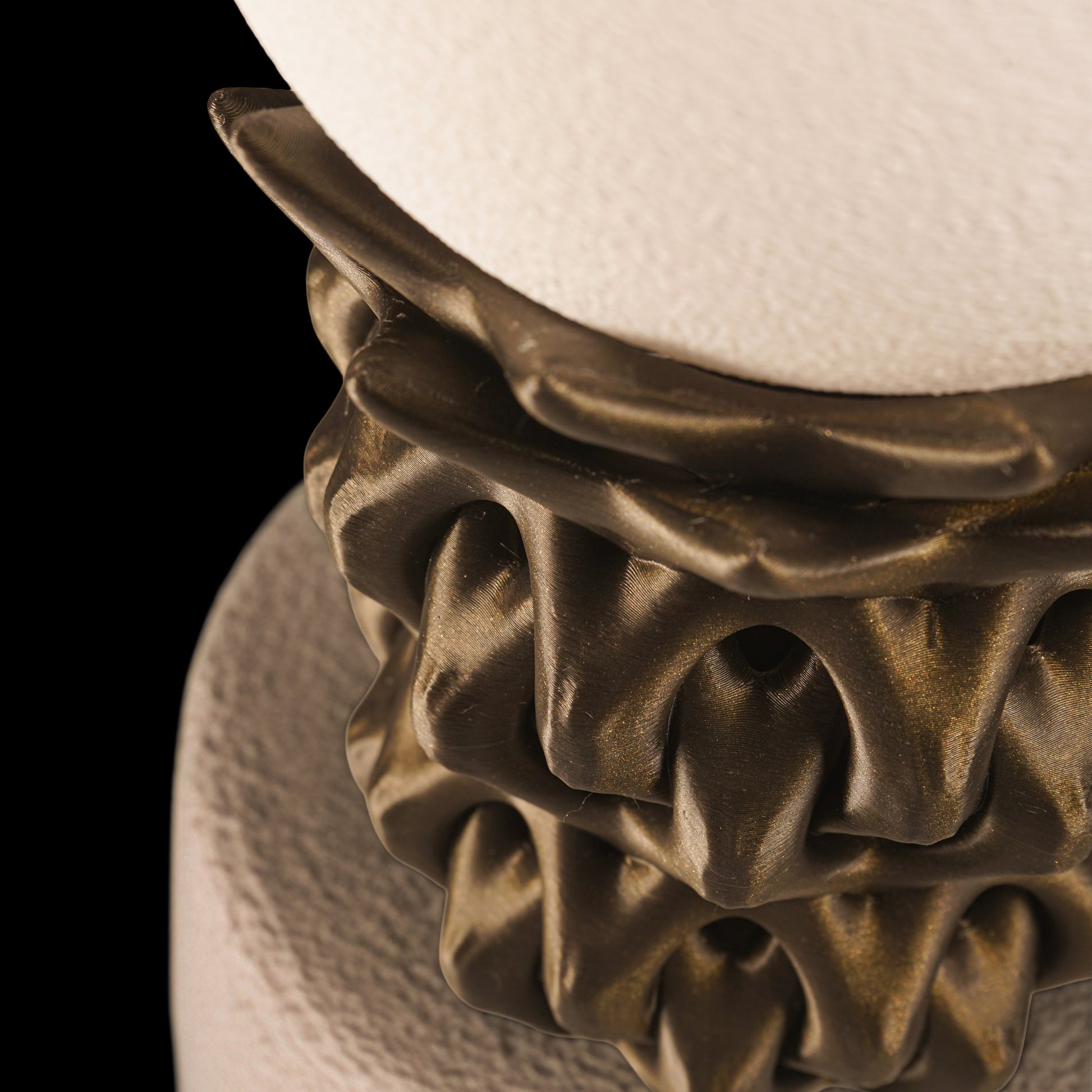 Decorative lamp with textured base and white shade on a black background