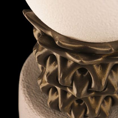 Decorative lamp with textured base and white shade on a black background